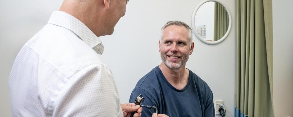 Doctor consulting smiling male patient