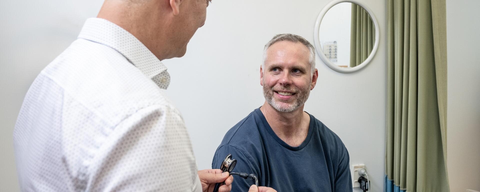 Doctor consulting smiling male patient