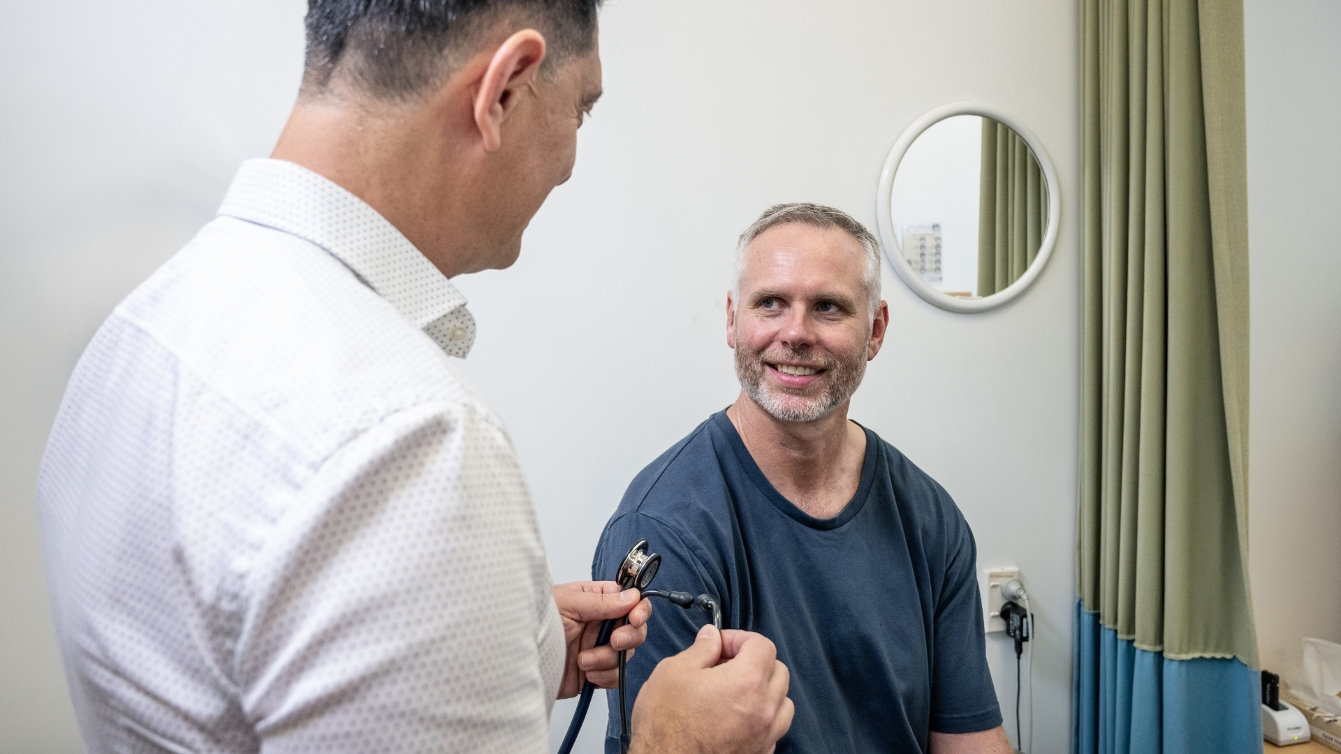 Doctor consulting smiling male patient