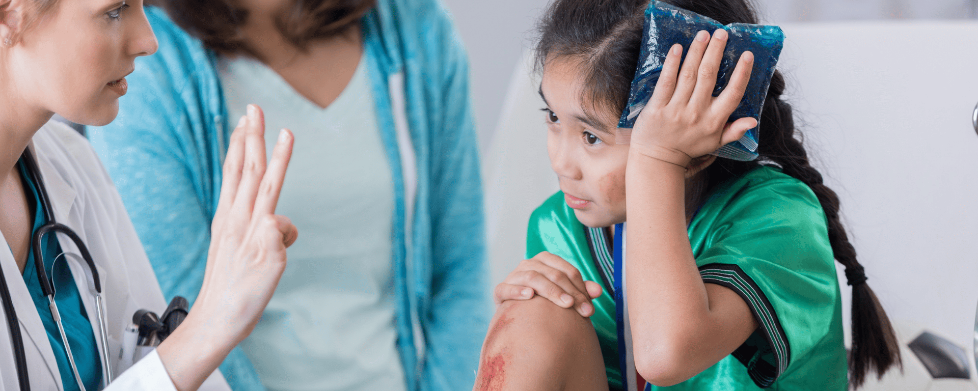 Doctor holding finger up, bruised child holidng ice pack to head