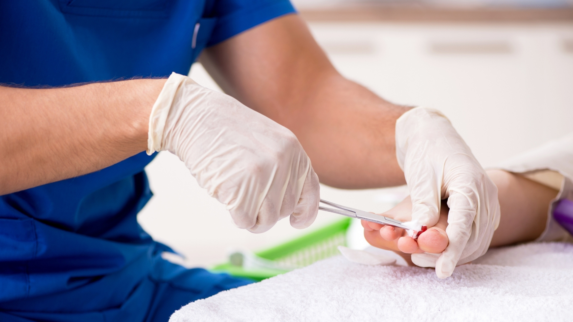 Gloved doctor's hand treating patient's foot