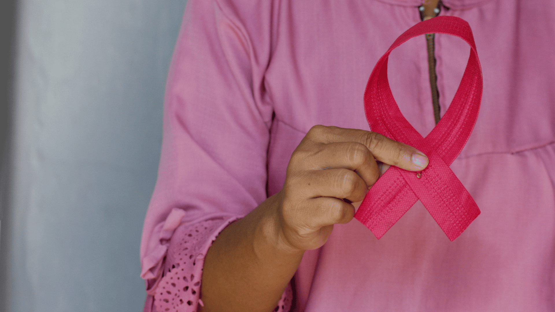 Hand holding pink ribbon