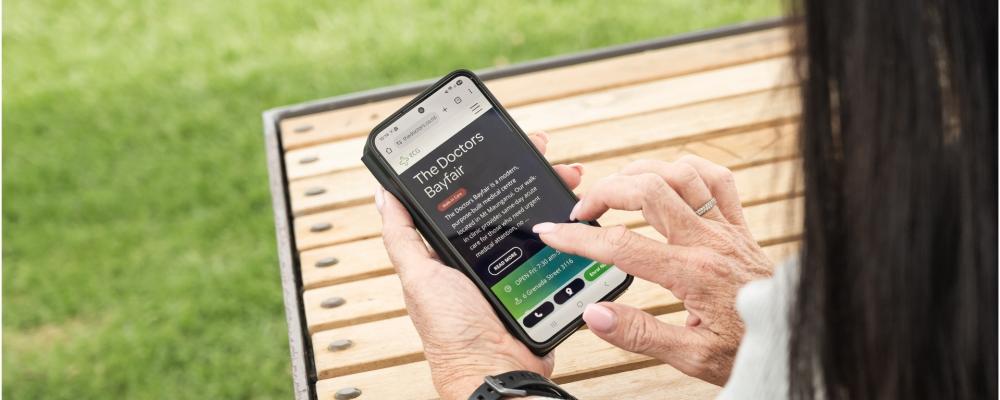 Hand on smartphone with TD website