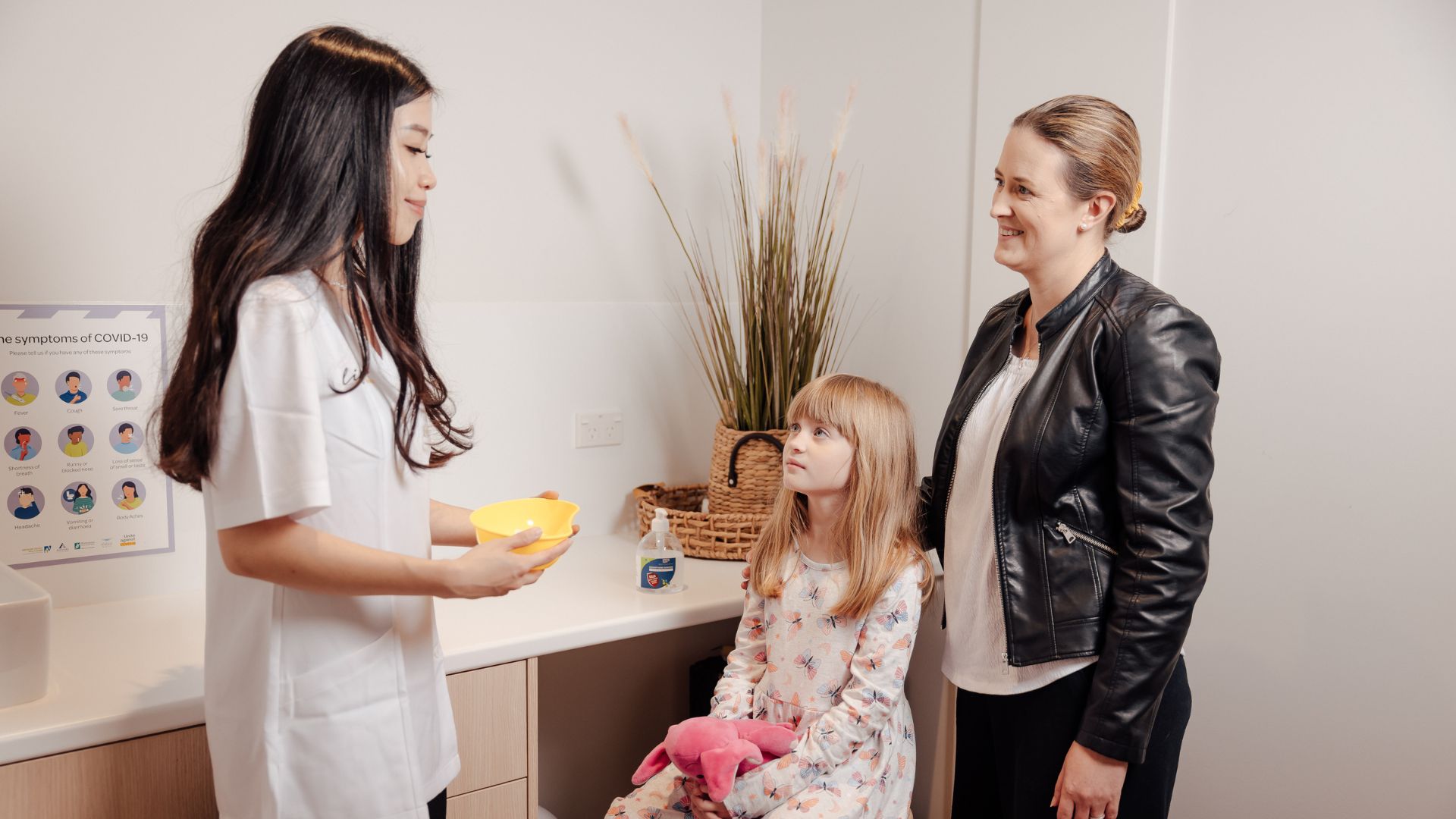 Image of female pharmacist helping mother and daughter