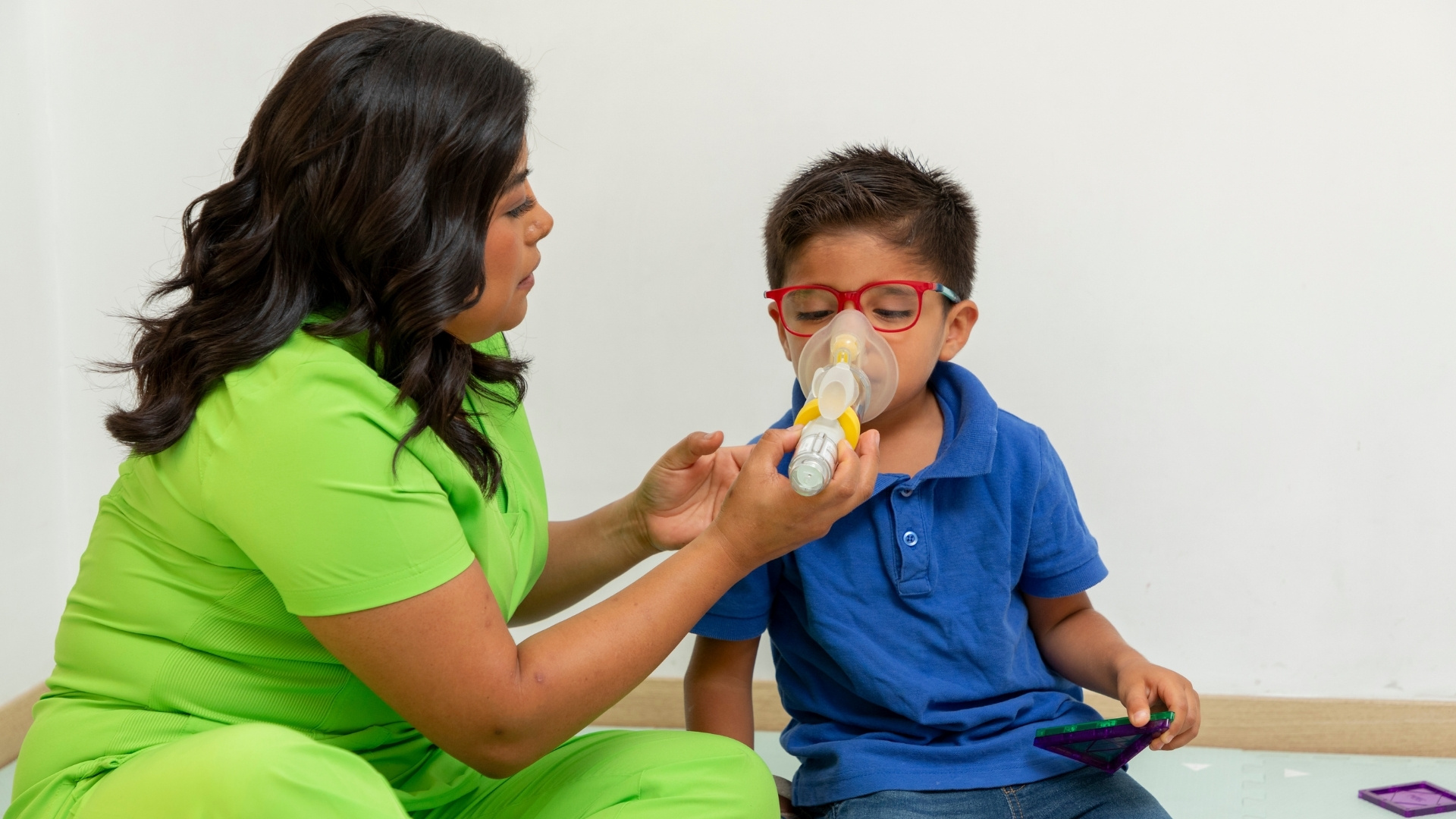 Mom giving boy inhaler