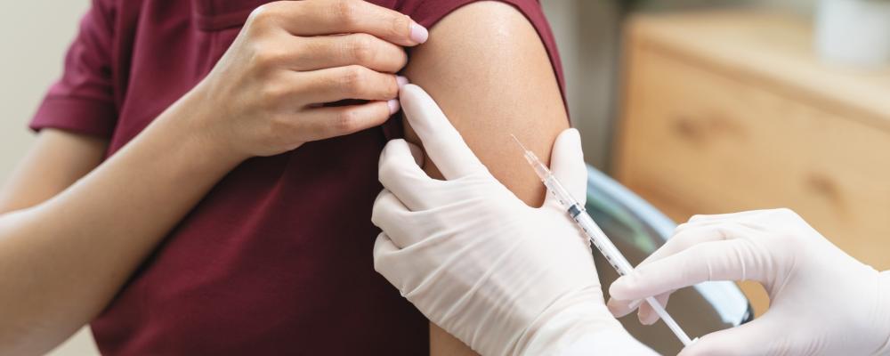 Patient in brown shirt getting vaccinated