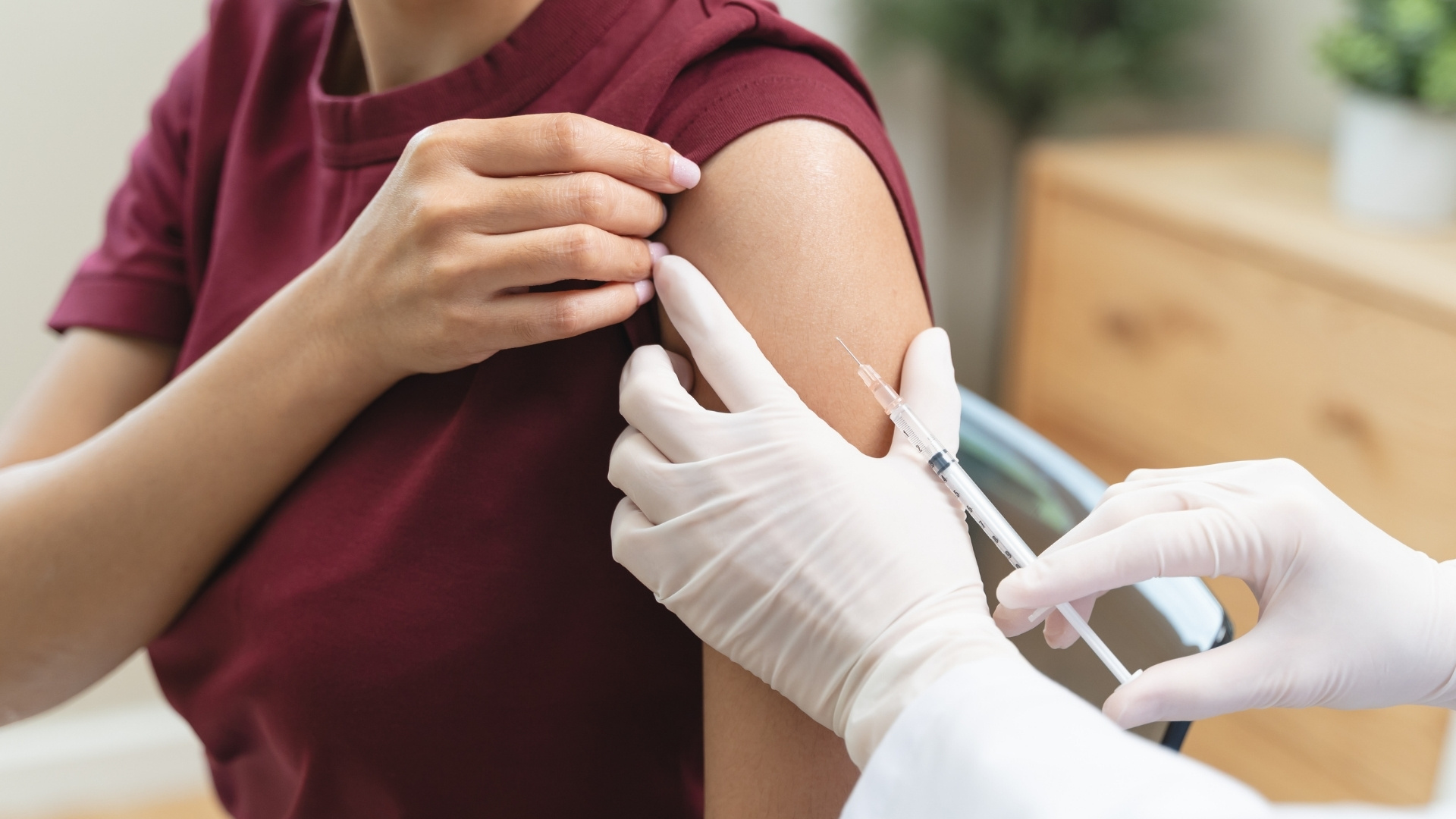 Patient in brown shirt getting vaccinated