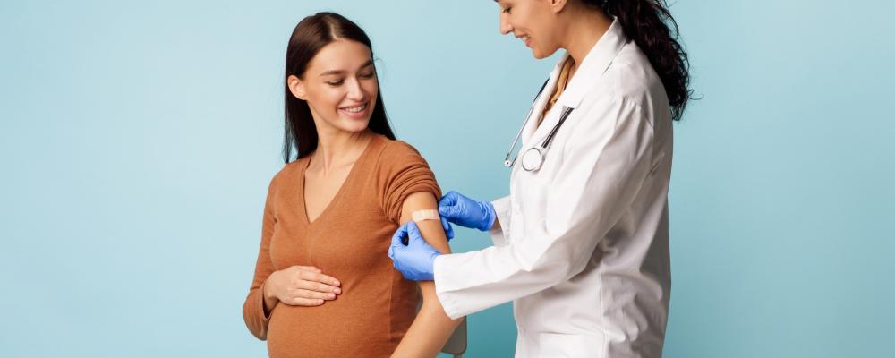 Pregnant woman getting vaccinated by a doctor