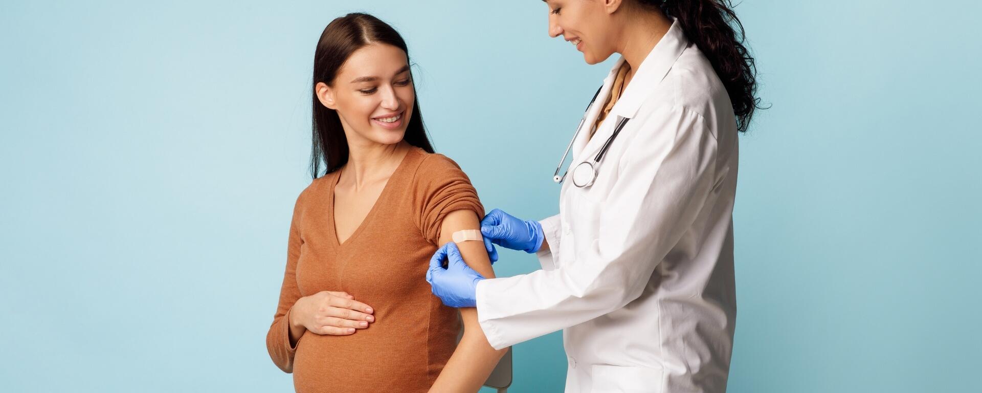 Pregnant woman getting vaccinated by a doctor