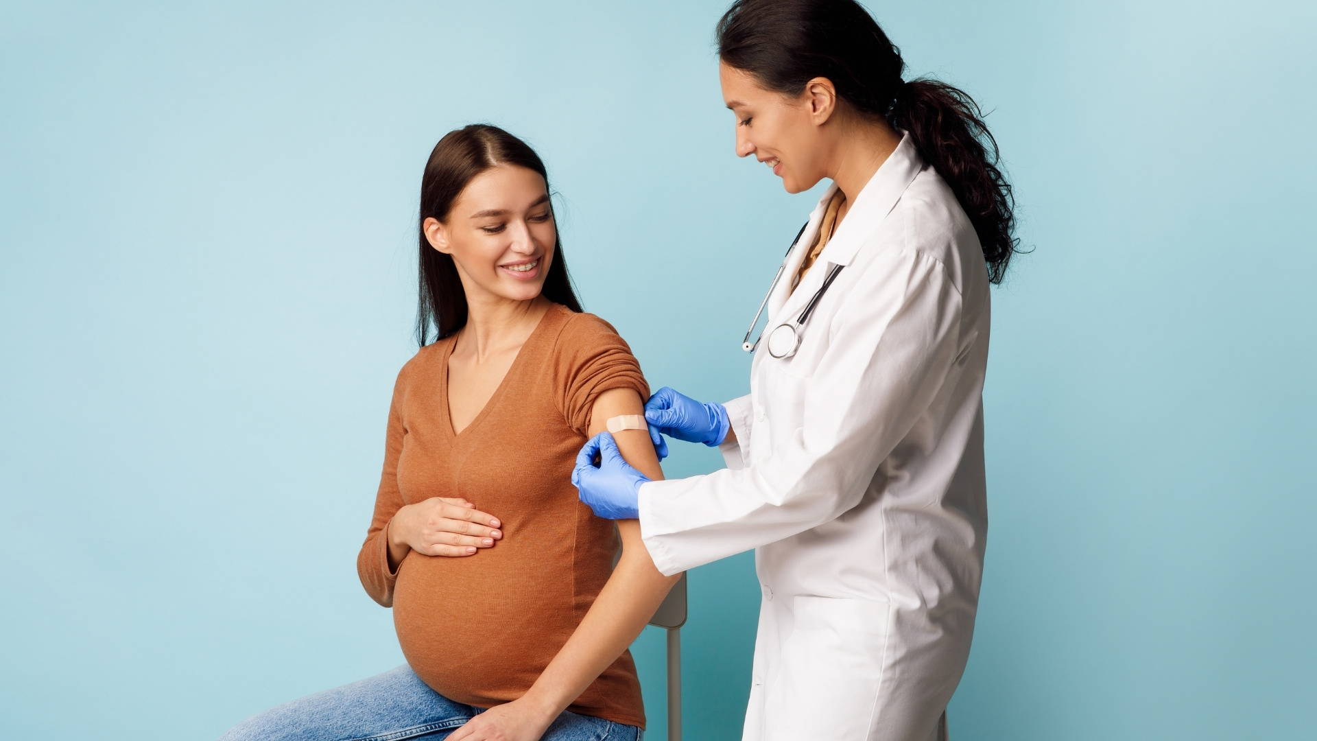 Pregnant woman getting vaccinated by a doctor