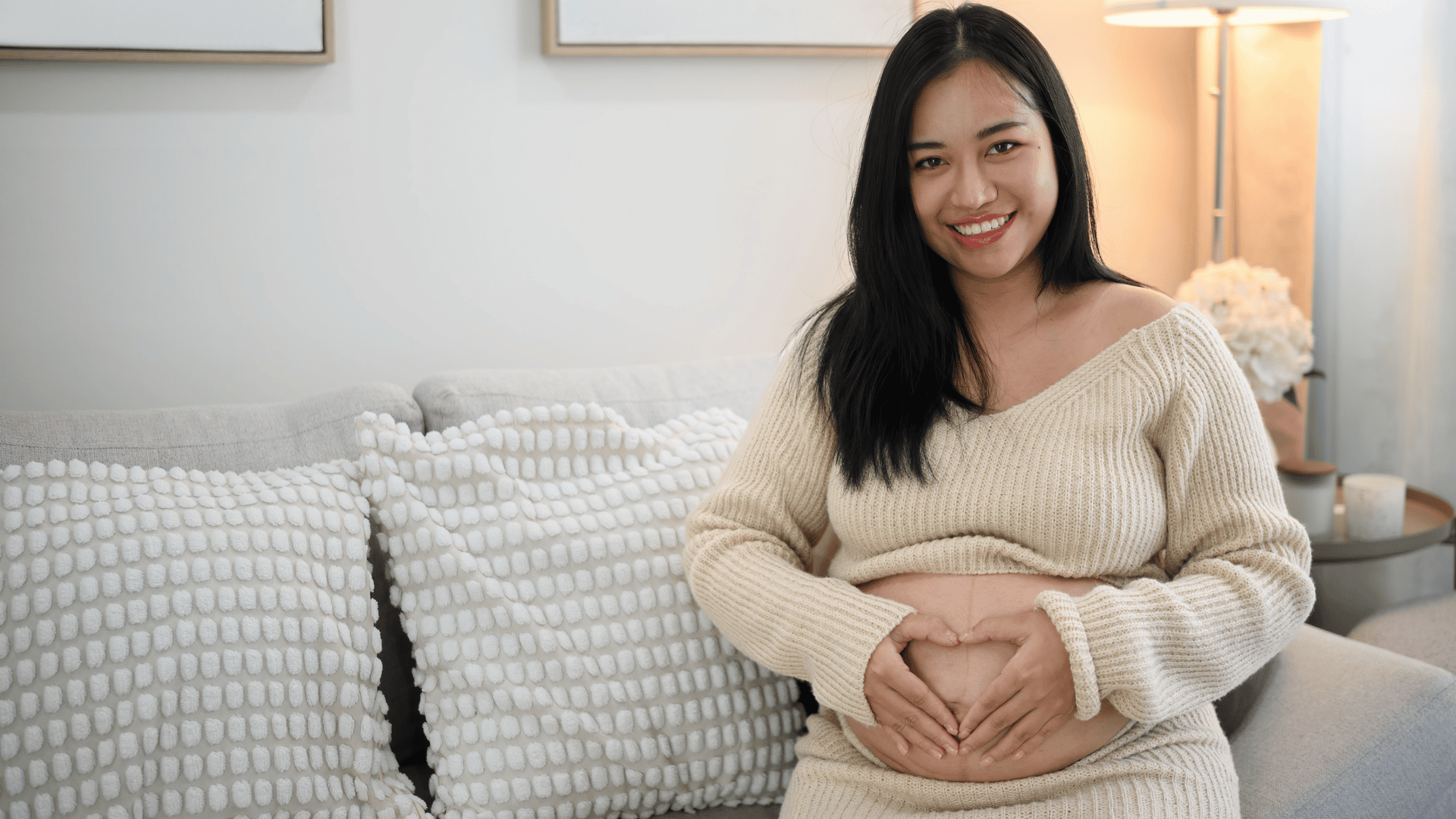 Pregrant woman smiling sitting on couch