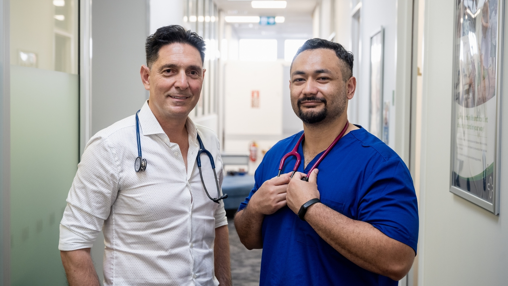 Two GPs smiling at camera
