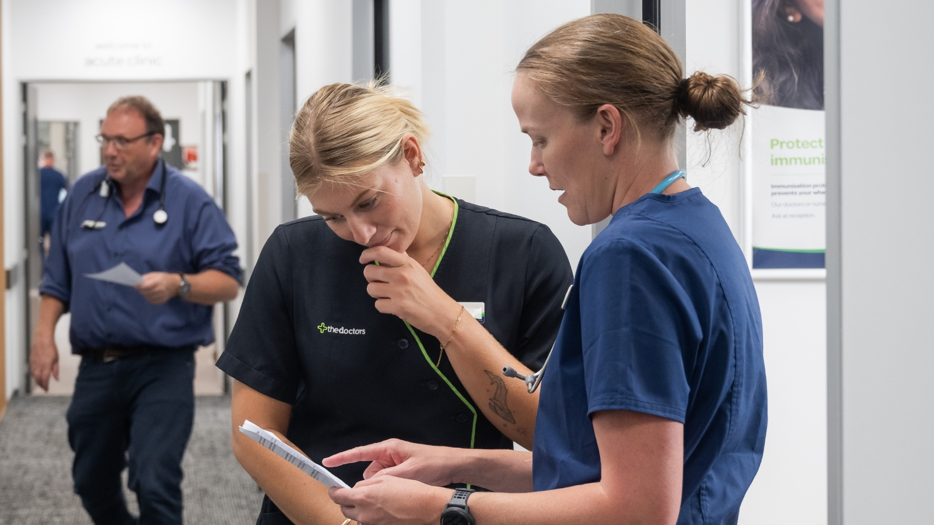 Two nurses looking at document