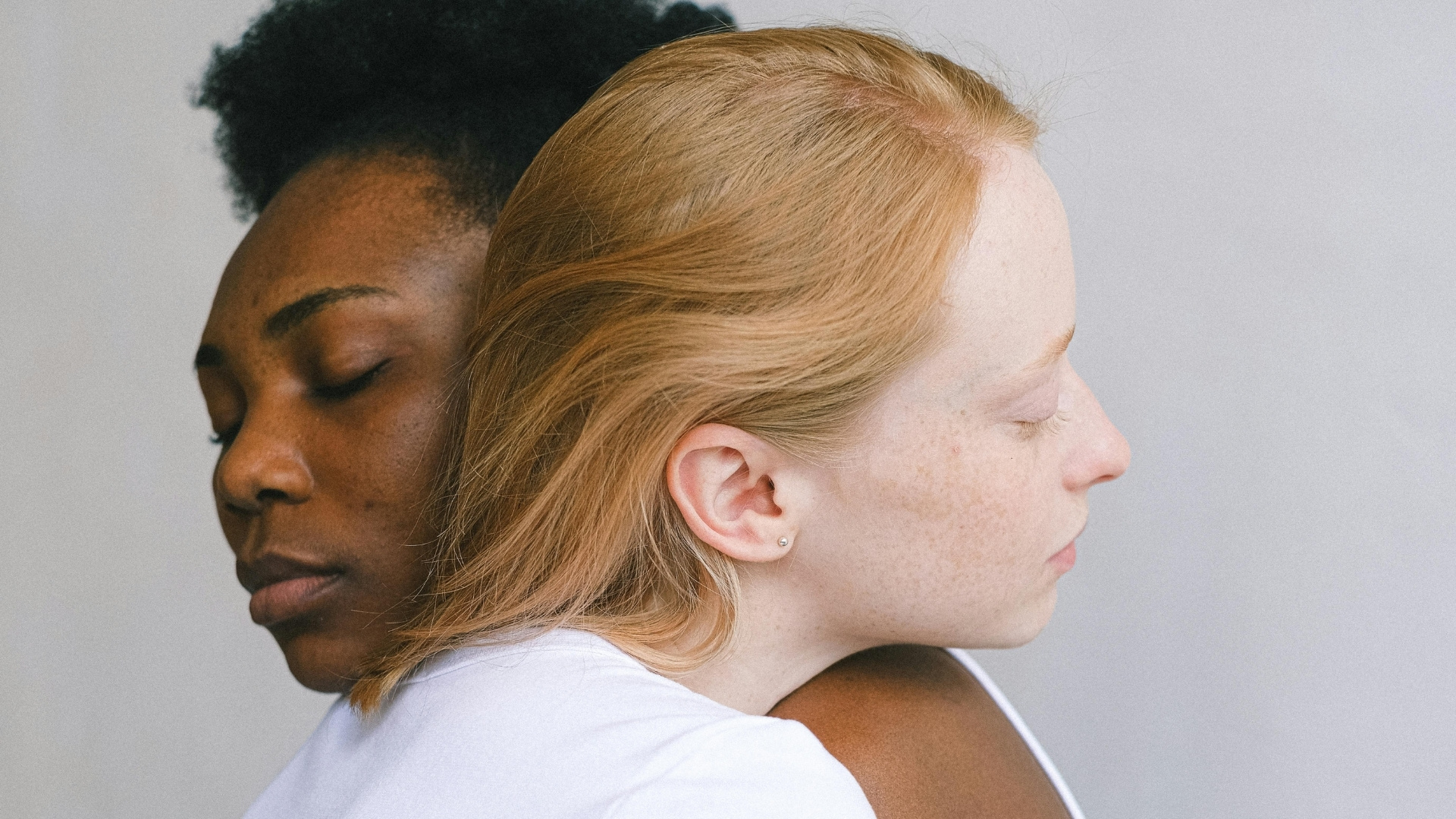Two women hugging closed eyes