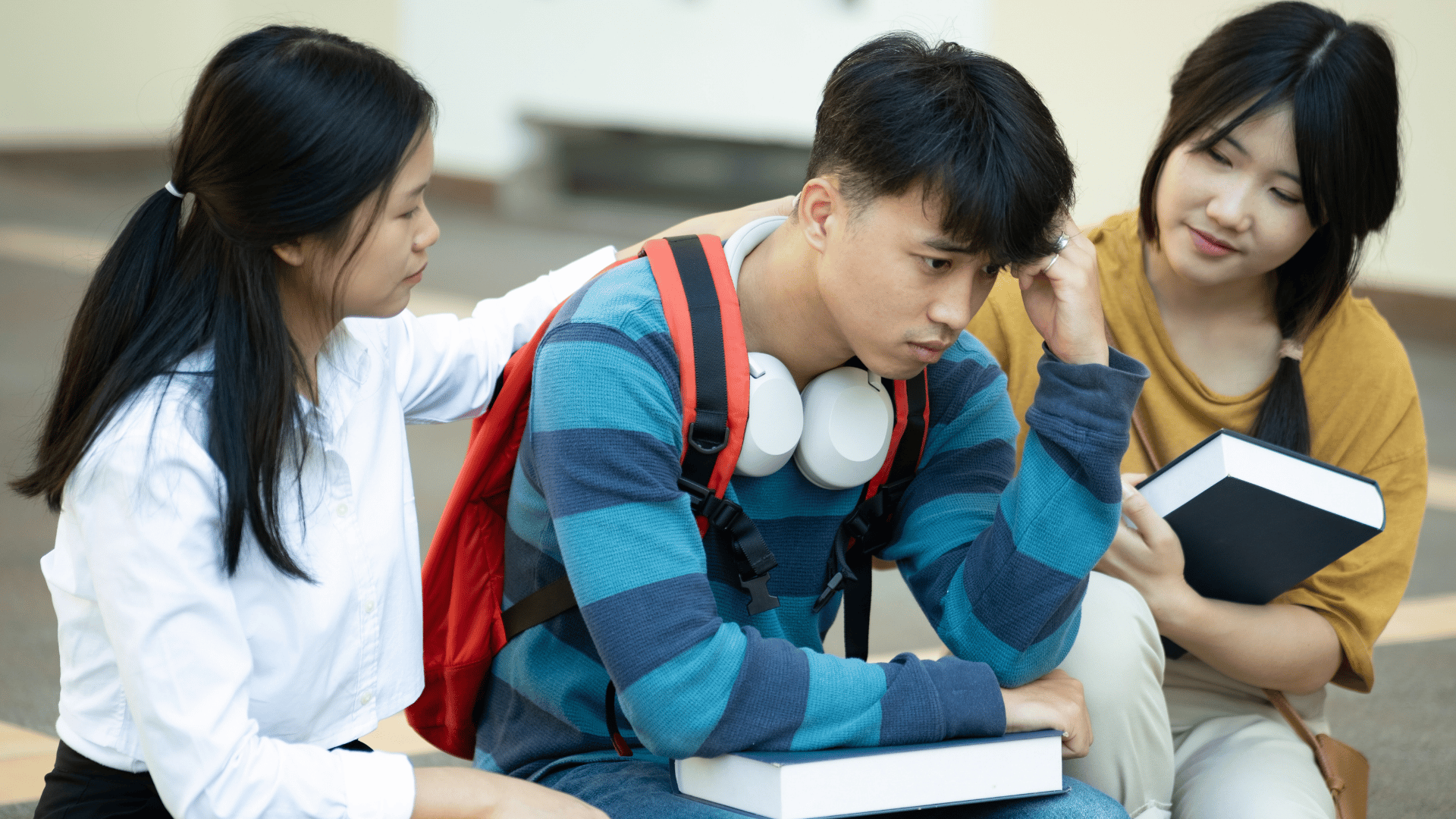 Two youths consoling their friend