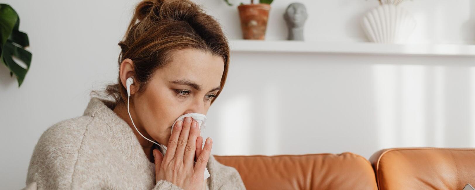 Woman sneezing on couch