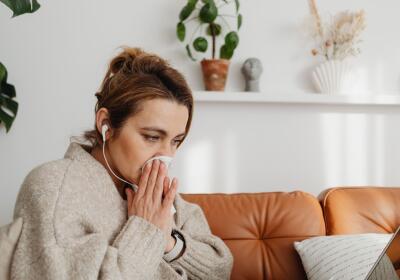 Woman sneezing on couch