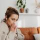 Woman sneezing on couch