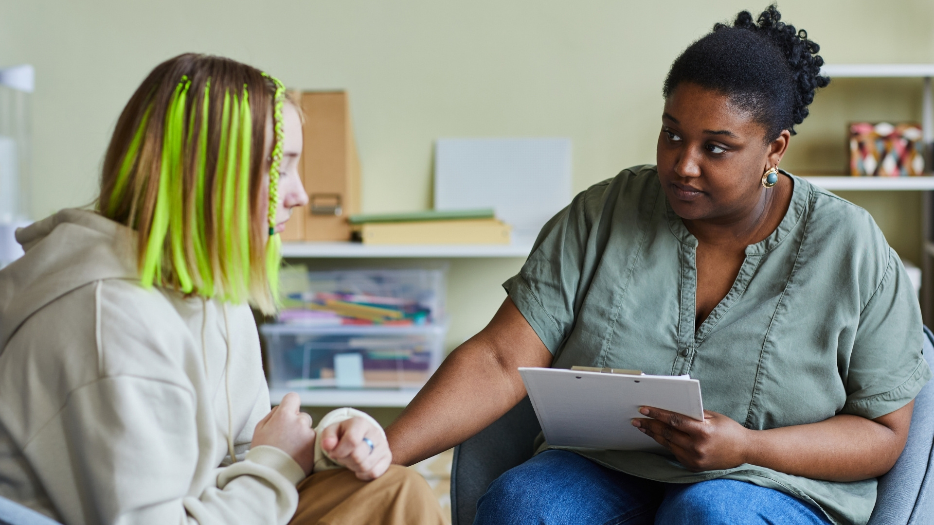 mental health counselor comforting teenager green hair