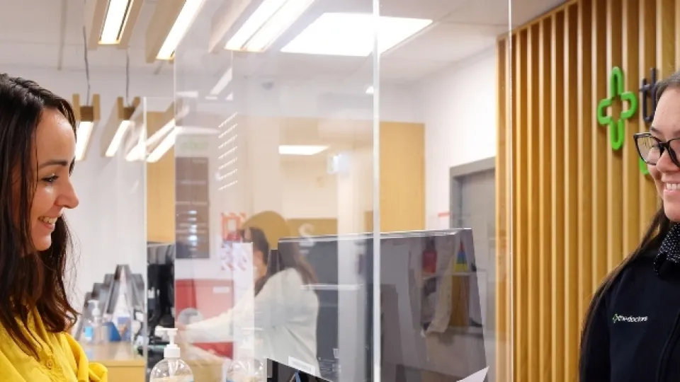 Patient talking with friendly receptionist at The Doctors