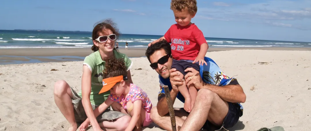 Happy family enjoy NZ summer at beach