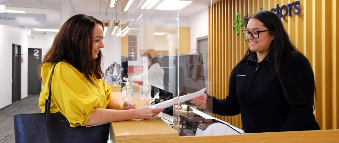 Friendly receptionist at medical centre greets patient
